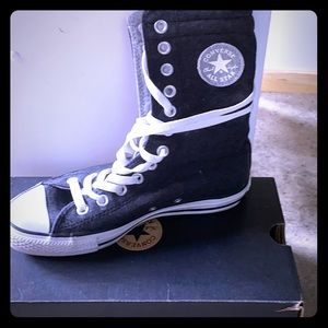 Grey woman’s converse high tops.